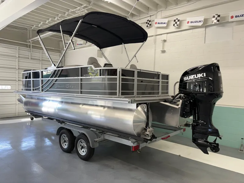 Slide: The Image of 2025 South Bay 222FCR pontoon boat with Suzuki outboard motor on trailer. - 2