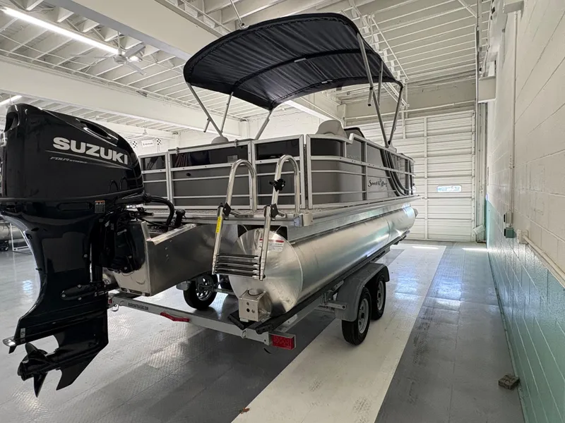 Slide: The Image of 2025 South Bay 222FCR pontoon boat with Suzuki outboard motor in a garage. - 5