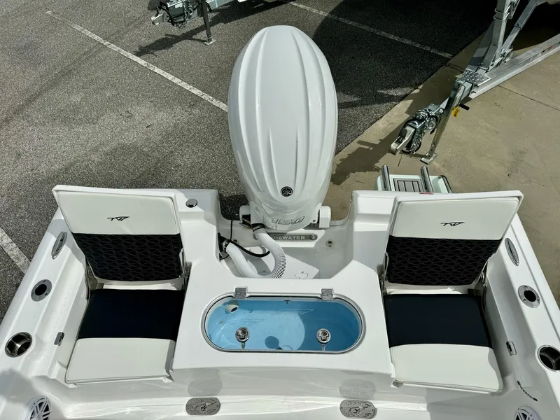 Slide: The Image of 2025 Tidewater 2110 Bay Max boat with dual seats and motor, parked on pavement. - 5