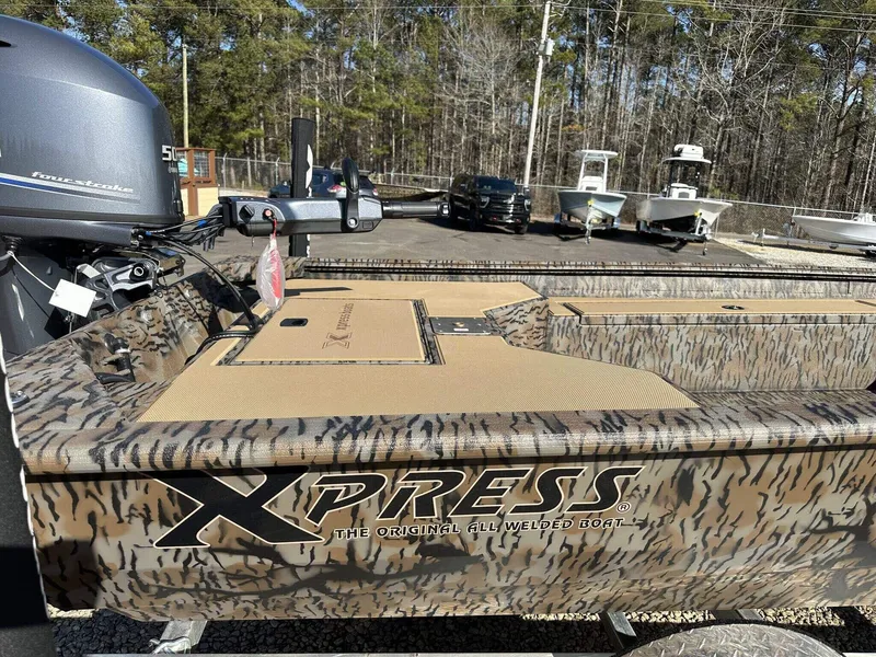 Slide: The Image of 2025 Xpress HD Series HD16DB boat with camo design and livewell, parked outdoors. - 7