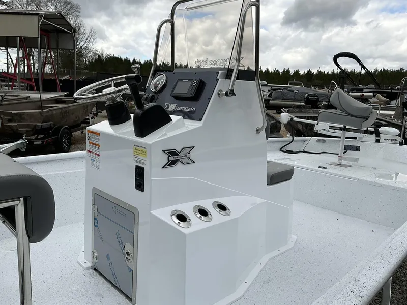 Slide: The Image of 2025 Xpress Xplorer Series XP20CC boat console with controls and seating, outdoors. - 8