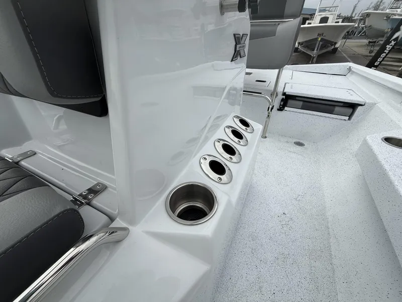 Slide: The Image of 2025 Xpress Hyper-Lift Series H22B boat interior with rod holders and seating. - 10