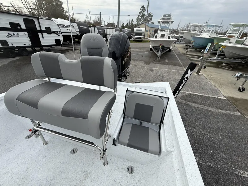 Slide: The Image of 2025 Xpress Hyper-Lift Series H22B boat with gray seating, parked in a marina. - 11