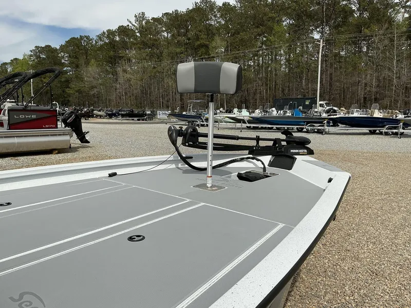 Slide: The Image of 2025 Xpress Hyper-Lift Bass Series boat with Minn Kota trolling motor in a boatyard. - 3