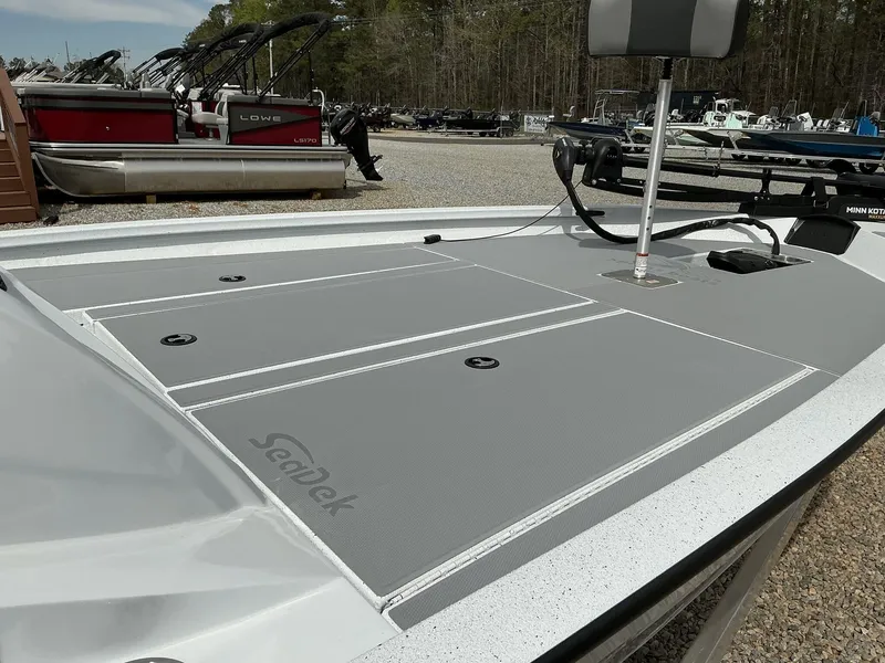 Slide: The Image of 2025 Xpress Hyper-Lift Bass Series boat with SeaDek flooring, parked among other boats. - 4