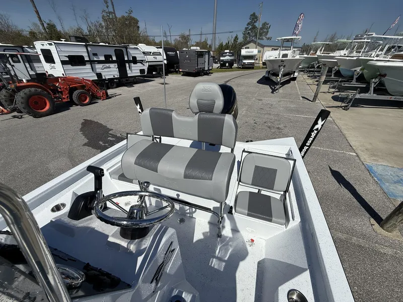 Slide: The Image of 2025 Xpress Hyper-Lift Series H20B boat console with seating, parked near RVs and boats. - 6