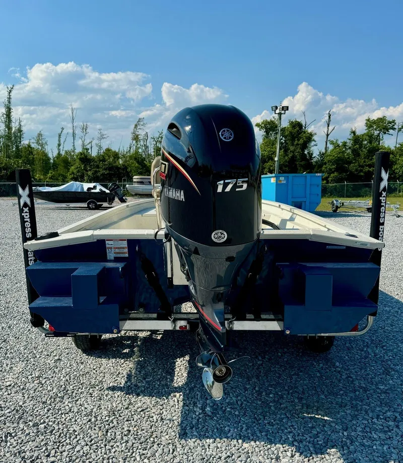 Slide: The Image of 2025 Xpress Shallow Water Series SW22B boat with Yamaha 175 engine, parked on gravel. - 6