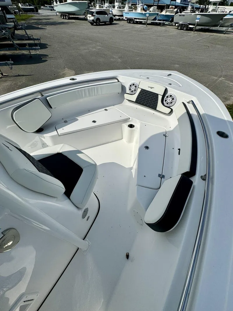 Slide: The Image of 2025 Tidewater 210 LXF boat interior with seating and speakers in a marina setting. - 8