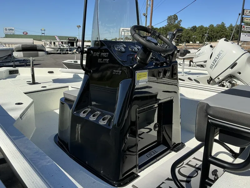 Slide: The Image of 2025 Excel Bay Pro 203 Elite boat with sleek console and Suzuki engine in a dealership. - 7