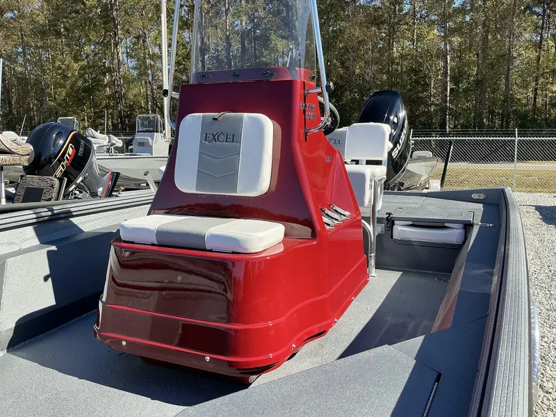 Slide: The Image of 2025 Excel Bay Pro 220 ELITE boat with red console and seating, outdoors. - 4