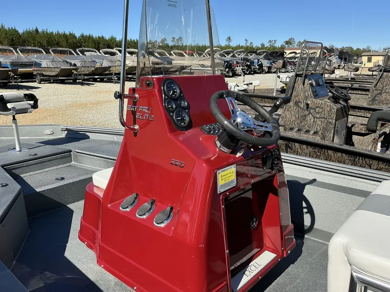 Slide: The Image of 2025 Excel Bay Pro 220 ELITE boat with red console and steering wheel. - 5