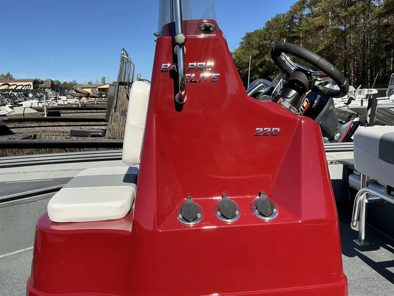 Slide: The Image of 2025 Excel Bay Pro 220 ELITE boat with red console and white seating. - 8