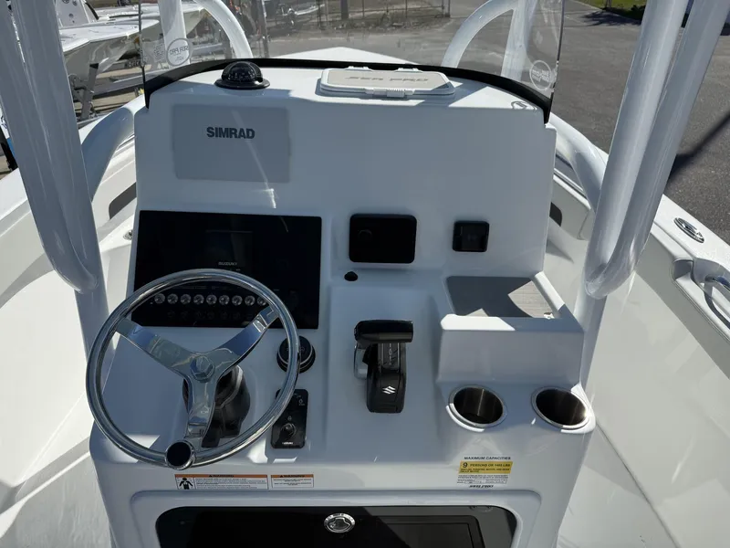 Slide: The Image of 2025 Sea Pro 222 boat console with steering wheel, Simrad display, and cup holders. - 11