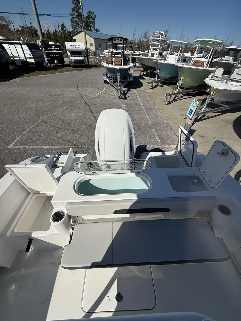 Slide: The Image of 2025 Sea Pro 222 boat interior with seating and storage, parked in a marina. - 12