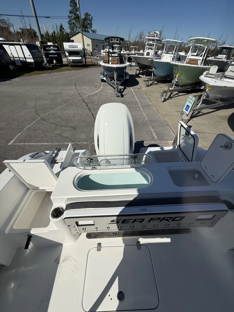 Slide: The Image of 2025 Sea Pro 222 boat interior with motor, parked among other boats. - 7