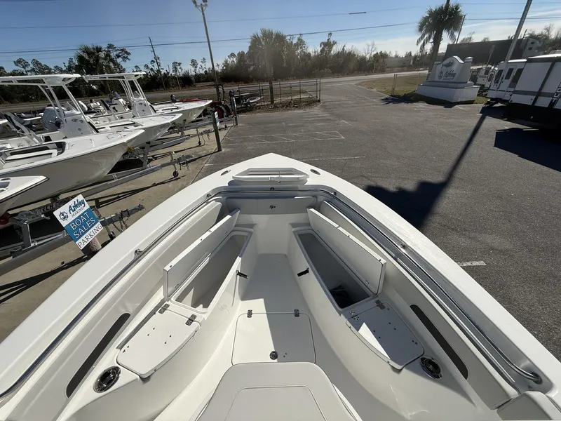 Slide: The Image of 2025 Sea Pro 222 boat interior with open storage compartments, displayed at a sales lot. - 8