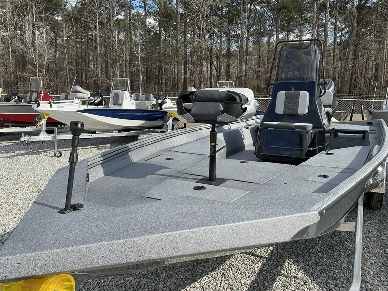 Slide: The Image of 2025 Excel New Bay Pro 230 SEADECK boat on display in a wooded area. - 13