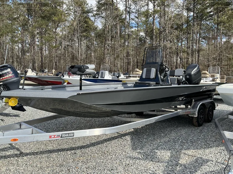 Slide: The Image of 2025 Excel New Bay Pro 230 SEADECK boat on trailer, surrounded by trees. - 14
