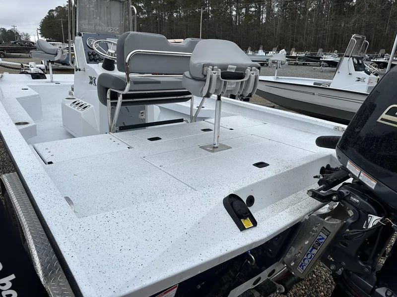 Slide: The Image of 2025 Xpress Hyper-Lift Series H22B boat with seating and motor, parked outdoors. - 4