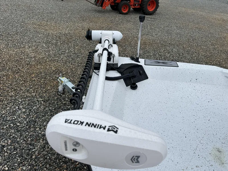 Slide: The Image of 2025 Xpress Hyper-Lift Series H22B boat with Minn Kota trolling motor on gravel surface. - 6