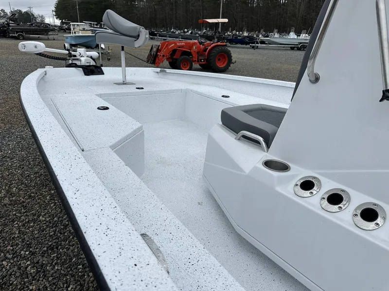 Slide: The Image of 2025 Xpress Hyper-Lift Series H22B boat with seating and rod holders, parked outdoors. - 7