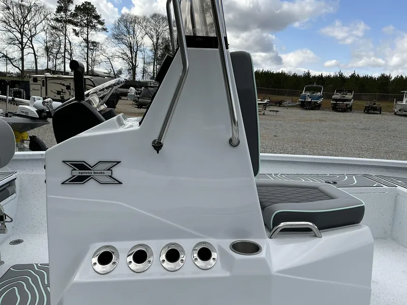 Slide: The Image of 2025 Xpress Hyper-Lift Series H20B console with seating, outdoors in a boatyard. - 10