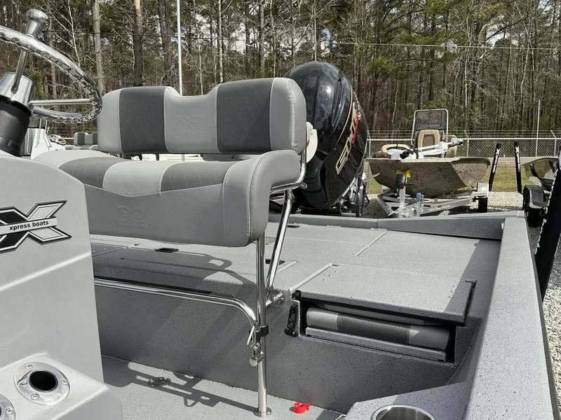 Slide: The Image of 2025 Xpress Hyper-Lift Series H22B boat interior with seating and motor, surrounded by trees. - 12