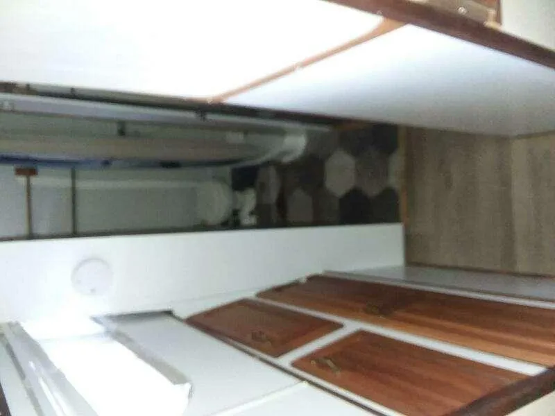 Slide: The Image of 1979 Chris-Craft 350 Catalina interior with wood cabinets and hexagonal floor tiles. - 10