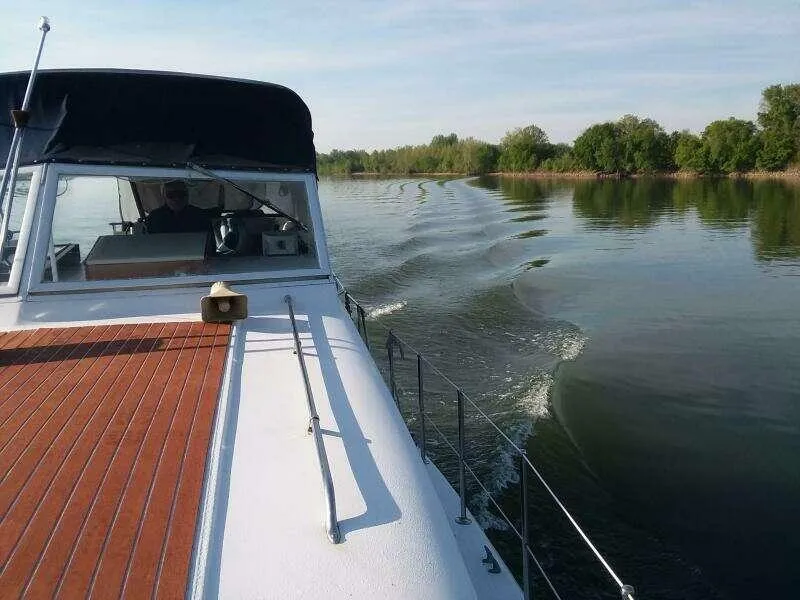 Slide: The Image of 1979 Chris-Craft 350 Catalina cruising on a calm lake with scenic greenery. - 4