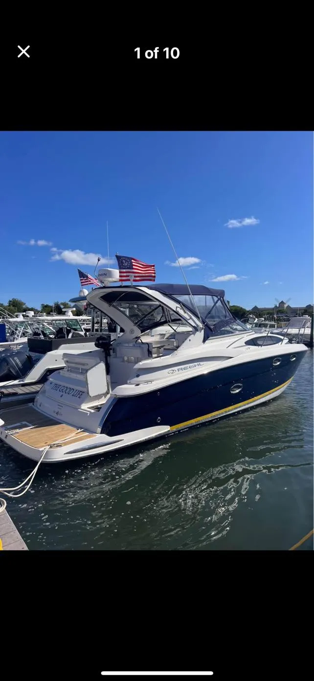 Slide: The Image of 2006 Regal 3360 Window Express boat docked, featuring sleek design and American flags. - 10