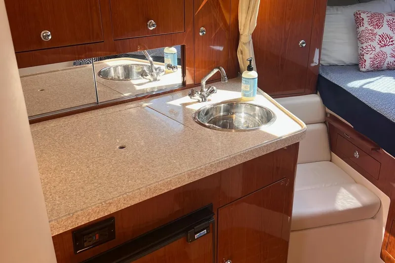 Slide: The Image of 2006 Regal 3360 Window Express boat interior with kitchenette and seating area. - 14