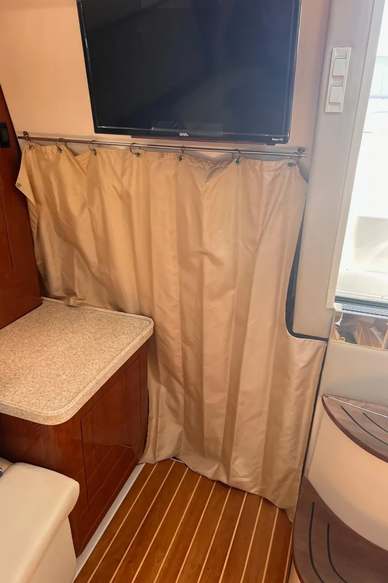 Slide: The Image of Interior of 2006 Regal 3360 Window Express with TV, curtain, and wooden flooring. - 20