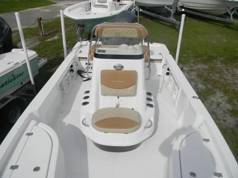 Slide: The Image of 2025 NauticStar 214 Shallow Bay boat with tan seating and center console. - 5