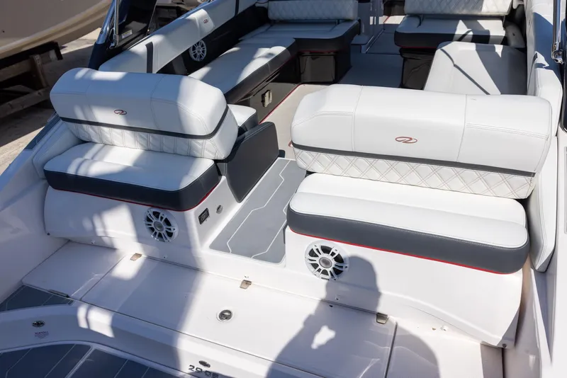 Slide: The Image of 2020 Regal 29 OBX boat interior with white cushioned seating and built-in speakers. - 20