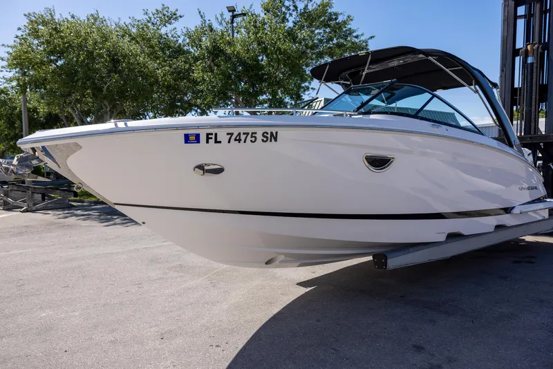 Slide: The Image of 2020 Regal 29 OBX boat on trailer, parked outdoors, with trees in background. - 3