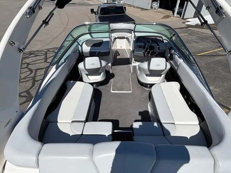 Slide: The Image of 2013 Regal 2300 Bowrider interior with seating and steering wheel, parked on pavement. - 12
