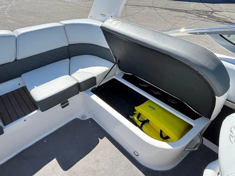 Slide: The Image of 2013 Regal 2300 Bowrider boat interior with open storage compartment and yellow bag. - 14