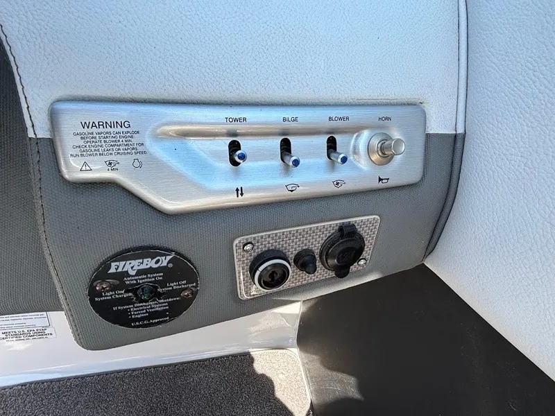 Slide: The Image of Control panel of a 2013 Regal 2300 Bowrider boat with switches and warning label. - 19