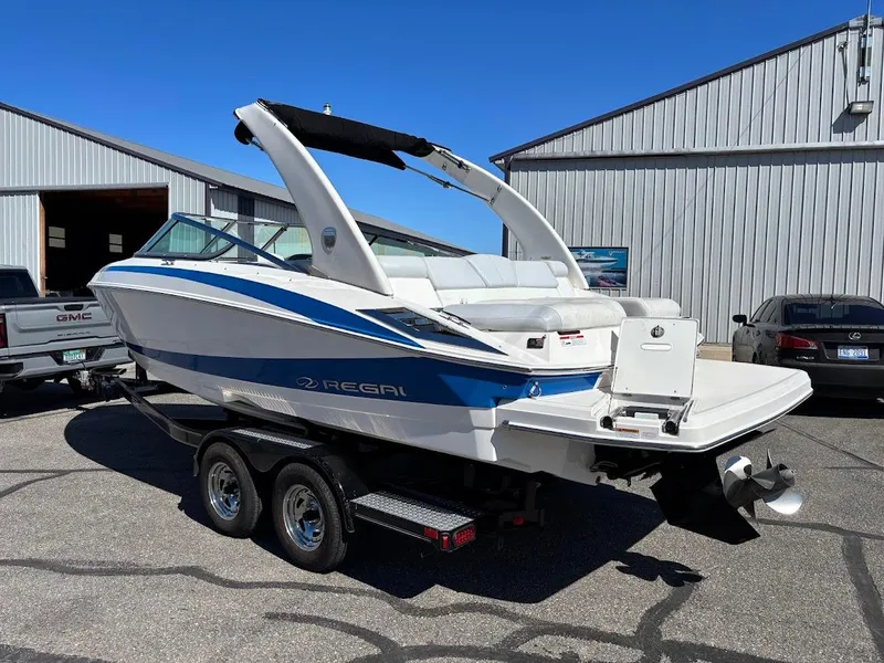 Slide: The Image of 2013 Regal 2300 Bowrider boat on trailer, parked outside a warehouse. - 3