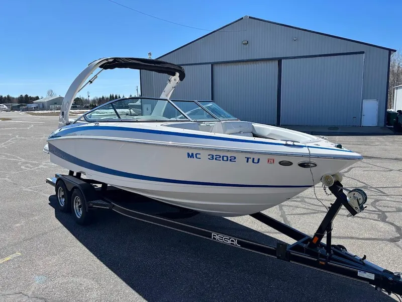 Slide: The Image of 2013 Regal 2300 Bowrider boat on trailer in outdoor setting. - 8