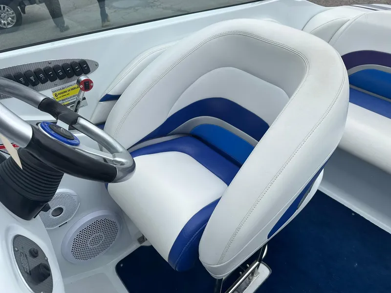 Slide: The Image of 2005 Baja 245 Performance boat interior with white and blue seating and steering wheel. - 12