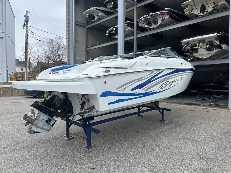 Slide: The Image of 2005 Baja 245 Performance boat with blue accents on a stand in a storage facility. - 2