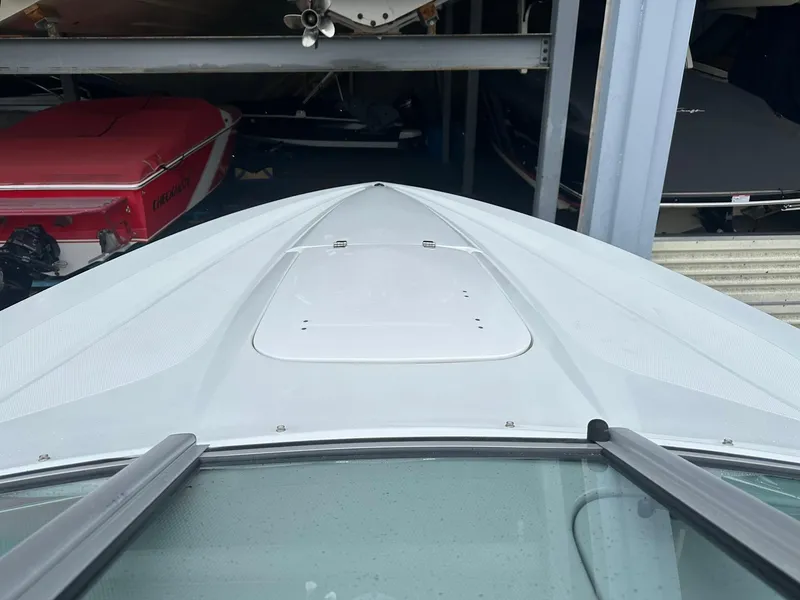 Slide: The Image of 2005 Baja 245 Performance boat bow in storage, showcasing sleek design and white finish. - 21