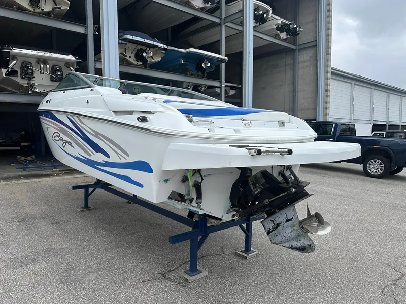 Slide: The Image of 2005 Baja 245 Performance boat in storage, featuring blue and white design. - 3