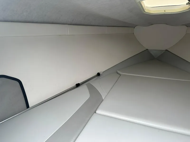 Slide: The Image of 2005 Baja 245 Performance boat interior cabin with cushioned seating and overhead hatch. - 8