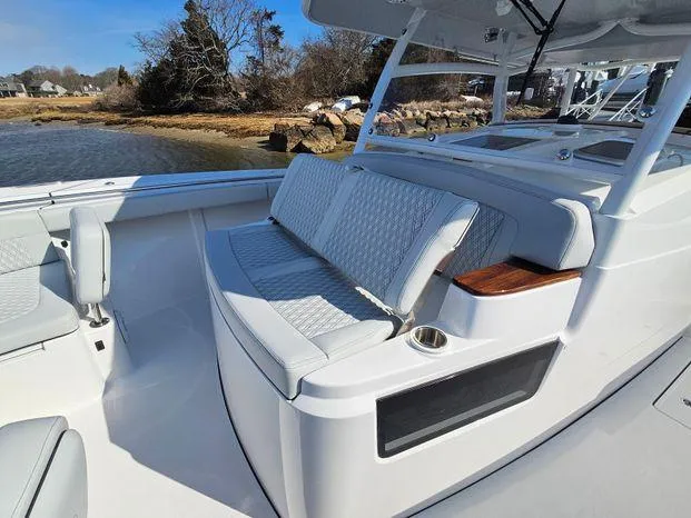 Slide: The Image of 2025 Southport 38 FE boat interior with cushioned seating and cup holder. - 24