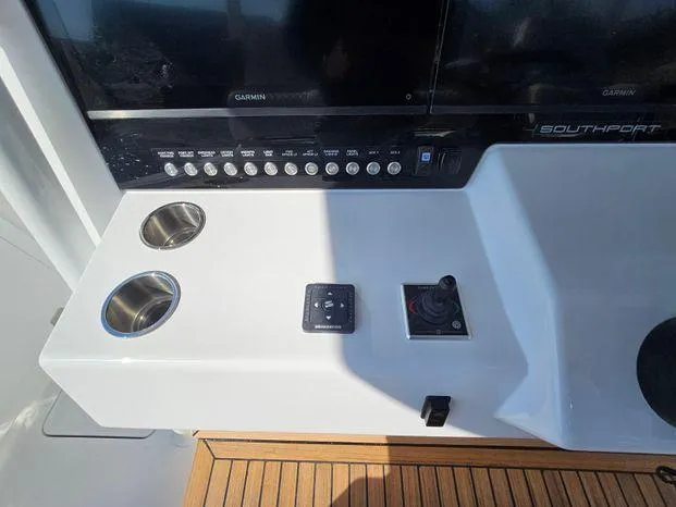 Slide: The Image of Control panel of 2025 Southport 38 FE boat with cup holders and navigation controls. - 25