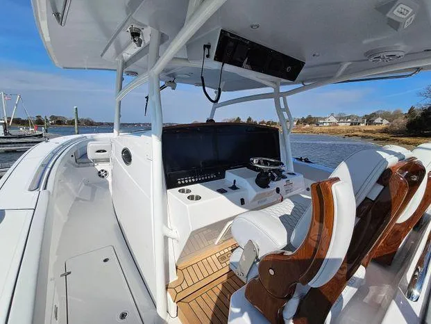 Slide: The Image of 2025 Southport 38 FE boat interior with helm, wooden seats, and water view. - 32