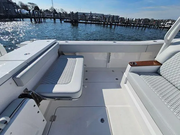 Slide: The Image of 2025 Southport 38 FE boat interior with cushioned seating, dockside view. - 37