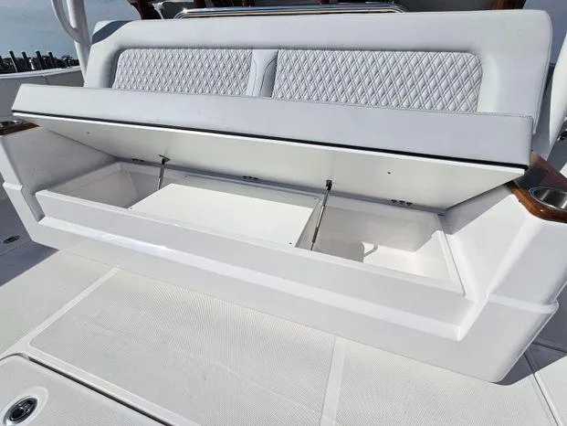 Slide: The Image of 2025 Southport 38 FE boat with open storage compartment and cushioned seating. - 40